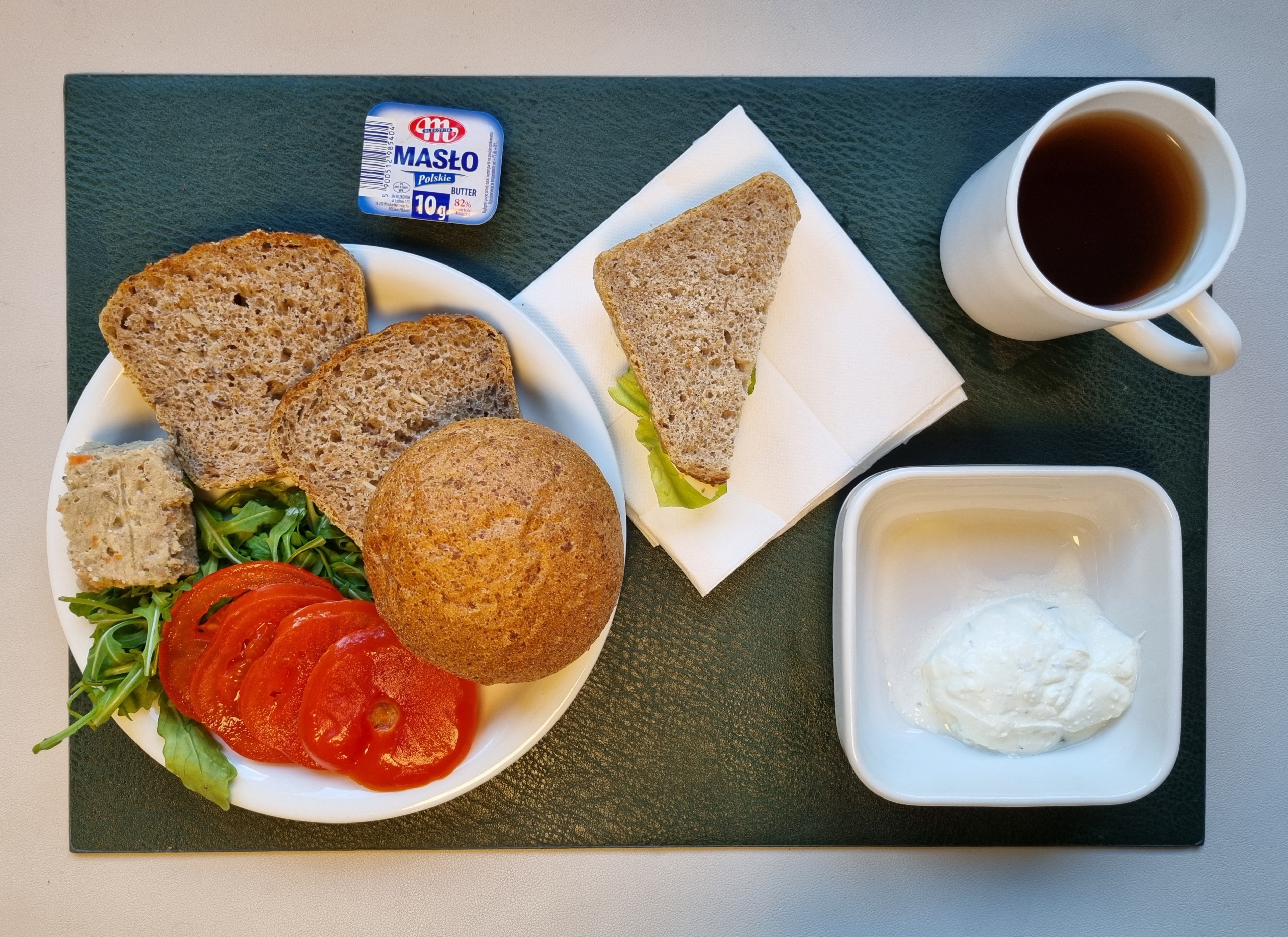 Bułka graham-pszenna 50g 1 szt ( GLU PSZ,) Chleb ze słonecznikiem i lnem-pszenno-żytni 60 g ( GLU PSZ, GLU ŻYT, ) Masło porcjowane 10g (82% tł.) 1 szt ( MLE,) Pasztet wieprzowy z warzywami + 50 g ( GLU PSZ, JAJ, SOJ, MLE, SEL, ) Twarożek z koperkiem + 50 g ( MLE,) Plastry pomidora + 110 g Rukola 10 g Herbata czarna ekspresowa z cytryną Cateringowa b/c 250 ml