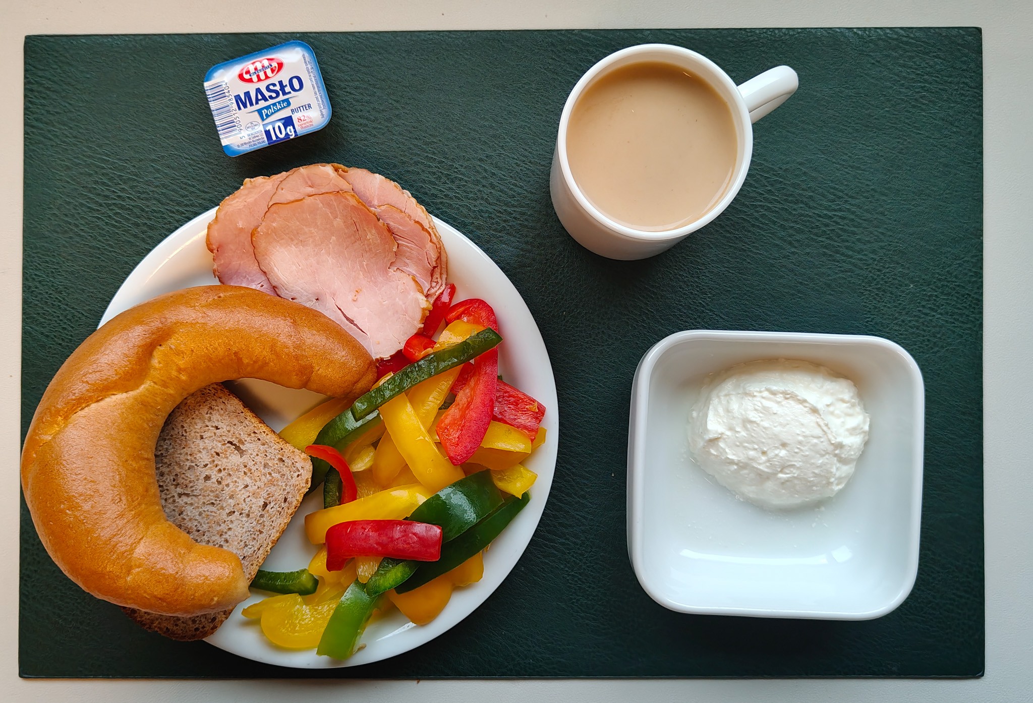 Rogal drożdżowy 50g 1 szt ( GLU PSZ, MLE, GLU ŻYT, ) Chleb Graham 30 g ( GLU PSZ,) Masło porcjowane 10g (82% tł.) 1 szt ( MLE,) Szynka Wiejska wędzona, wieprzowa, wędzona, pieczona 50 g ( może zawierać: GLU PSZ, SOJ, MLE, SEL, GOR, S02, ) Twarożek domowy waniliowy + 50 g ( MLE, może zawierać: GLU PSZ, JAJ, OZI, SOJ, MLE, ORZ, SEZ,) Słupki papryki kolorowej + 120 g Kakao z mlekiem b/c 250 ml ( MLE,) Cukier 5 g