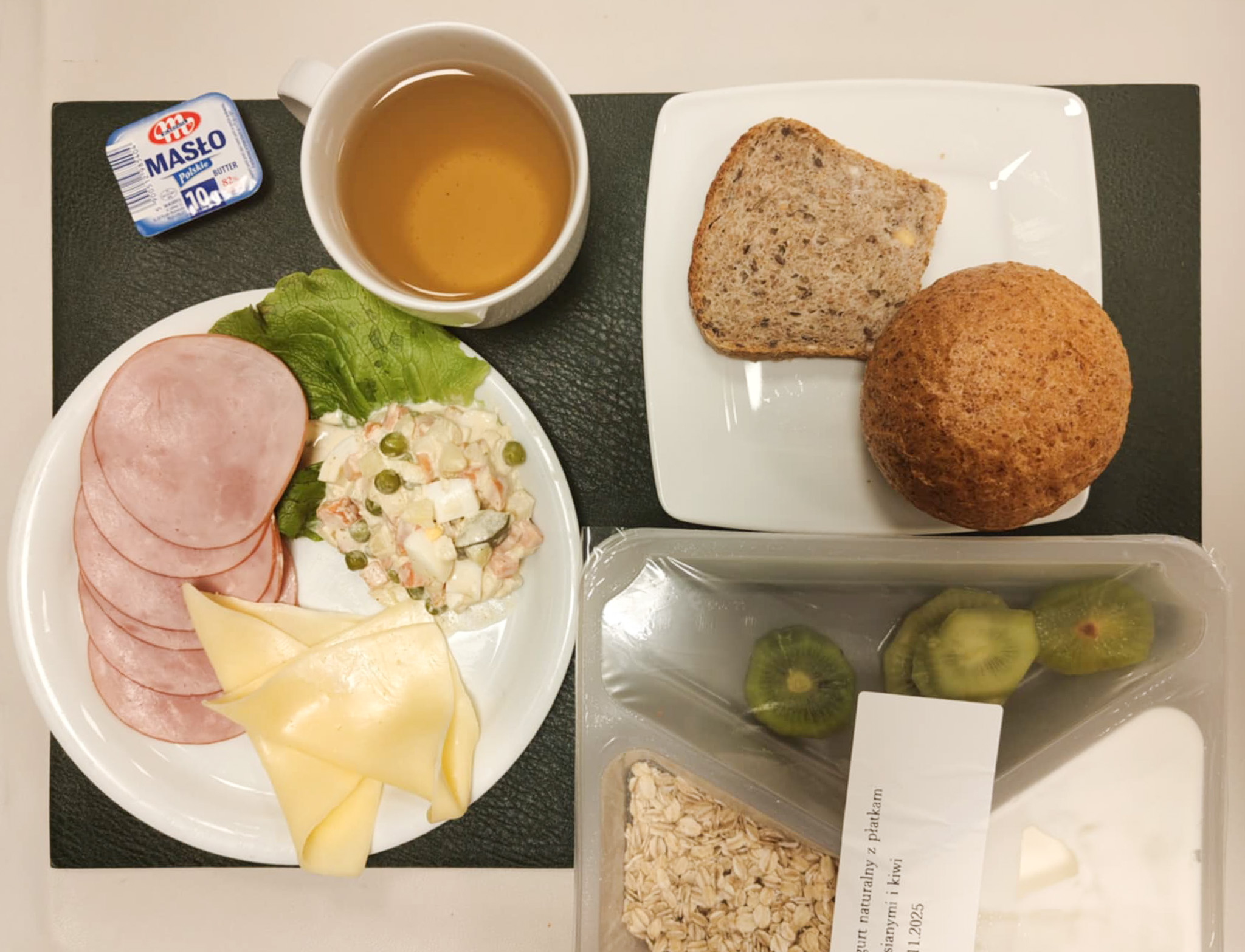 Bułka graham-pszenna 50g 1 szt ( GLU PSZ,) Chleb wieloziarnisty 30 g ( GLU PSZ, SOJ, SEZ, GLU ŻYT, ) Masło porcjowane 10g (82% tł.) 2 szt ( MLE,) Ser żółty 30 g (MLE,) Szynkowa dębowa kieł.wp.gr.rozd.wędz.parzo.z dodat.wody w osł.niejad 50 g Sałatka jarzynowa z jajkiem dieta + 120 g ( JAJ, MLE, SEL,) Sałata zielona 10 g Herbata czarna ekspresowa z cytryną Cateringowa b/c 250 ml