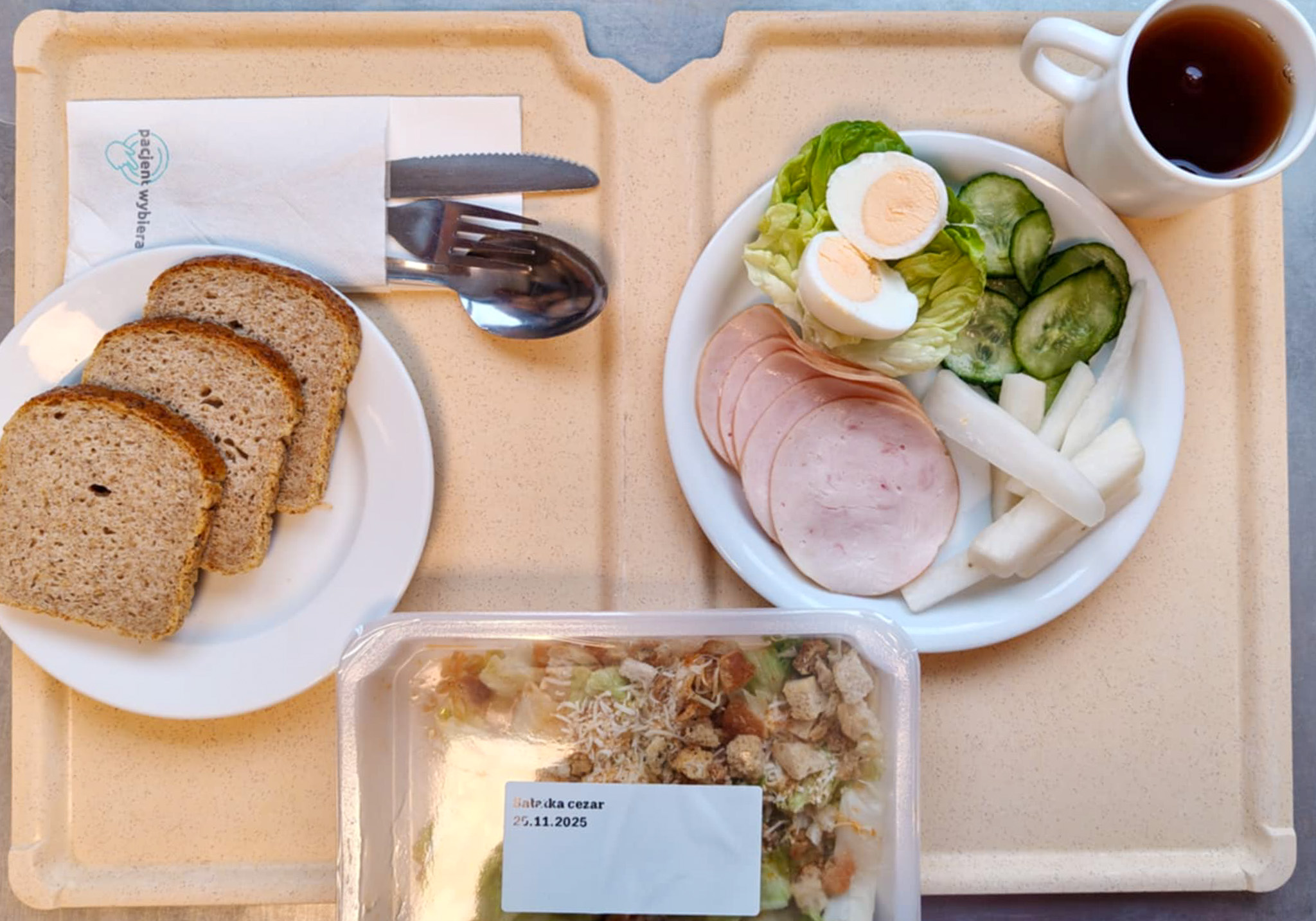 Chleb mieszany razowy żytnio-pszenny 80 g ( GLU PSZ, GLU ŻYT, ) Masło porcjowane 10g (82% tł.) 1 szt ( MLE,) Jajko gotowane kl M + 1 szt ( JAJ,) Szynkowa dębowa drobiowa kiełbasa grubo rozdrobniona 50 g Plastry ogórka świeżego + 50 g Słupki rzodkwi białej + 50 g Sałata zielona 20 g Herbata czarna ekspresowa z cytryną Cateringowa b/c 250 ml  II śniadanie: Sałatka cezar + 120 g ( GLU PSZ, MLE,)