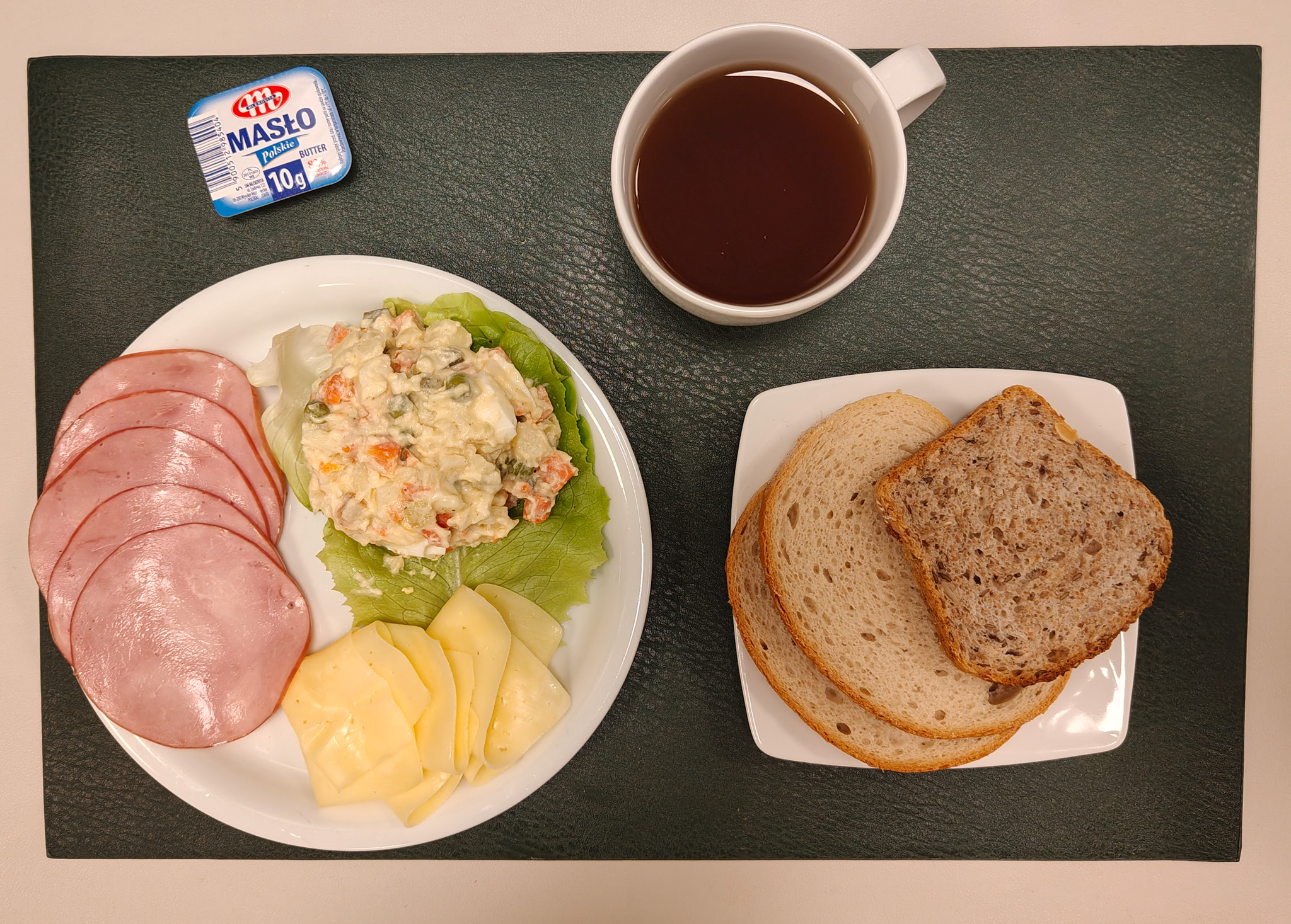 Chleb mieszany pszenno-żytni 50 g ( GLU PSZ, GLU ŻYT, ) Chleb wieloziarnisty 30 g ( GLU PSZ, SOJ, SEZ, GLU ŻYT, ) Masło porcjowane 10g (82% tł.) 2 szt ( MLE,) Ser żółty 30 g (MLE,) Szynkowa dębowa kieł.wp.gr.rozd.wędz.parzo.z dodat.wody w osł.niejad 50 g Sałatka jarzynowa z jajkiem + 120 g ( JAJ, MLE, SEL, GOR, ) Sałata zielona 10 g Herbata czarna ekspresowa z cytryną Cateringowa b/c 250 ml Cukier 5 g