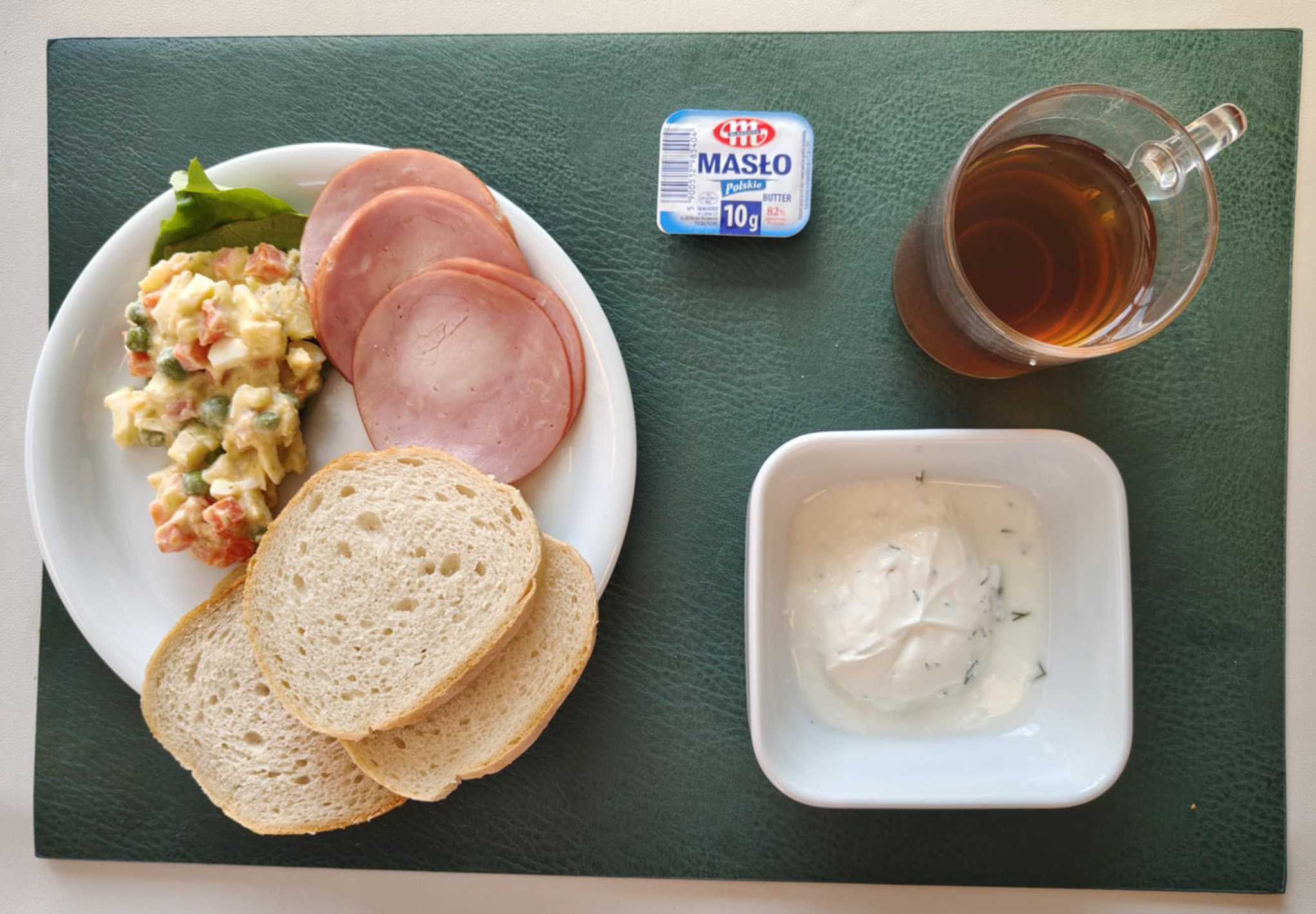 Chleb mieszany pszenno-żytni 50 g ( GLU PSZ, GLU ŻYT,) Bułka pszenna długa krojona 30 g (GLU PSZ,) Masło porcjowane 10g (82% tł.) 2 szt ( MLE,) Pasta z twarogu z koperkiem + 50 g ( MLE,) Szynkowa dębowa kieł.wp.gr.rozd.wędz.parzo.z dodat.wody w osł.niejad 50 g Sałatka jarzynowa z jajkiem dieta + 120 g ( JAJ, MLE, SEL,) Sałata zielona 5 g Herbata czarna ekspresowa z cytryną Cateringowa b/c 250 ml Cukier 5 g