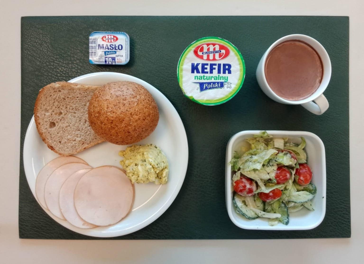 Bułka graham-pszenna 50g 1 szt ( GLU PSZ,) Chleb Graham 30 g ( GLU PSZ,) Masło porcjowane 10g (82% tł.) 1 szt ( MLE,) Szynkowa dębowa drobiowa kiełbasa grubo rozdrobniona 50 g Pasta jajeczna z awokado + 50 g ( JAJ, GOR,) Sałata lodowa z ogórkiem i pomidorkami koktajlowymi + 120 g ( MLE,) Kawa zbożowa z mlekiem b/c 250 ml ( MLE, GLU ŻYT, GLU JĘCZ, )
