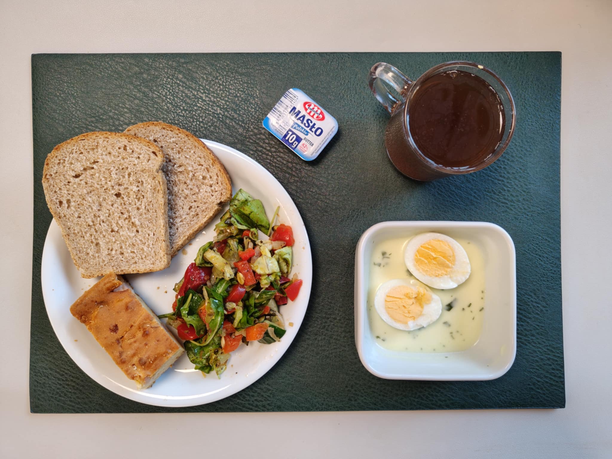 Wytrawny placek z mozzarellą i warzywami + 75 g ( GLU PSZ, JAJ, MLE, ) Chleb Graham 60 g (GLU PSZ,) Masło porcjowane 10g (82% tł.) 1 szt ( MLE,) Jajko w sosie jogurtowo-pietruszkowym + 100 g ( JAJ, MLE,) Sałatka wiosenna z dressingiem + 120 g ( SOJ,) Herbata czarna ekspresowa z cytryną Cateringowa b/c 250 ml