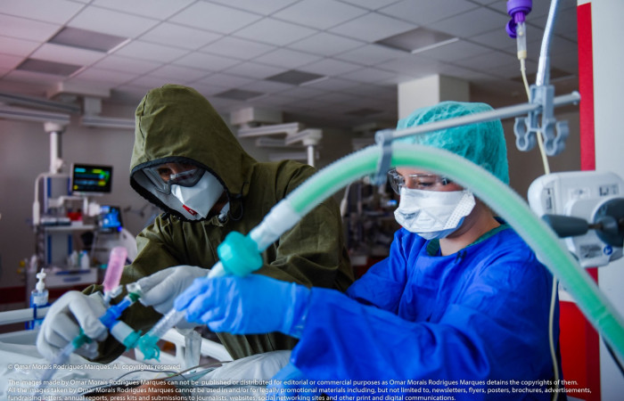 Pracownicy na strefie COVID-19 podpinają pacjenta do respiratora